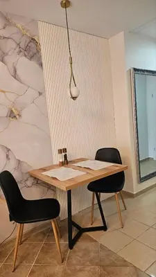 a wooden table and two chairs in a room at Vladan apartments in Sozopol