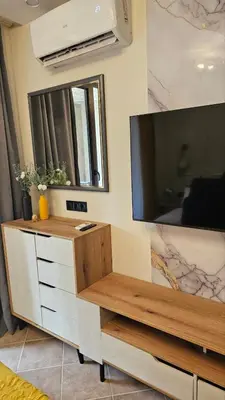 a living room with a large tv on a wall at Vladan apartments in Sozopol