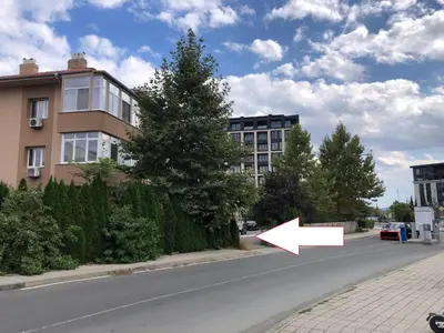 a street with a white arrow pointing to a building at Calendula in Burgas City