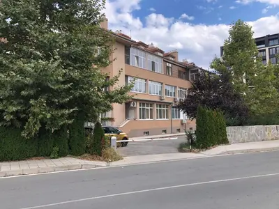 a building with a car parked in front of a street at Calendula in Burgas City