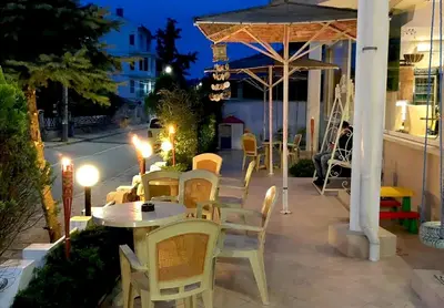 a table and chairs on a patio at night at Hotel Andre in Burgas City