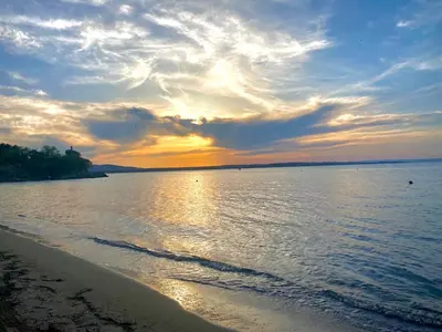 a sunset over a body of water with a beach at AJ Apartment 3, Santa Marina Holiday Village, Sozopol in Sozopol