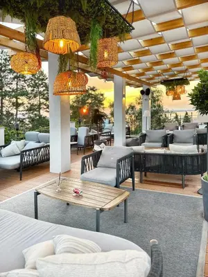 a patio with couches and tables and chandeliers at AJ Apartment 3, Santa Marina Holiday Village, Sozopol in Sozopol