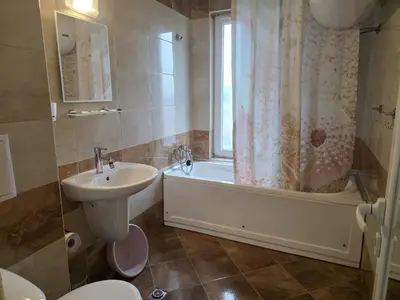 a bathroom with a tub and a sink and a toilet at Perla View Apartment in Primorsko