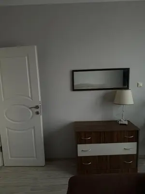 a room with a door and a table with a lamp at 
