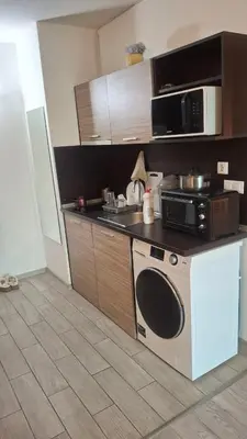 a kitchen with a microwave and a stove at Апартамент in Burgas City