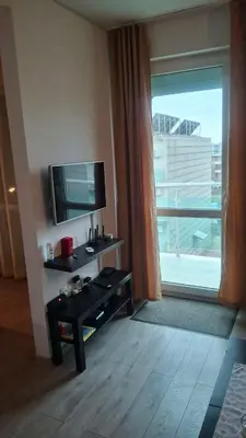 a living room with a television and a table with a table at Апартамент in Burgas City