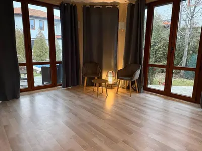 a living room with two chairs and large windows at Villa LUNA in Kableshkovo