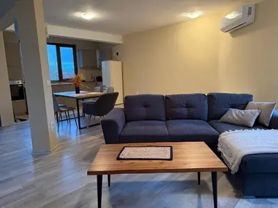 a living room with a blue couch and a table at Villa LUNA in Kableshkovo
