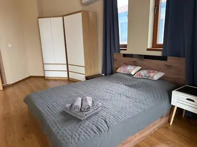 a bedroom with a bed with slippers on it at Villa LUNA in Kableshkovo