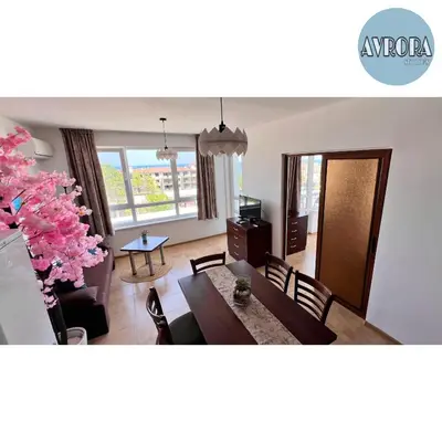 a living room with a dining table and a tree at Avrora Studio's in Byala