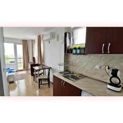 a kitchen with a sink and a dining room with a table at Avrora Studio's in Byala