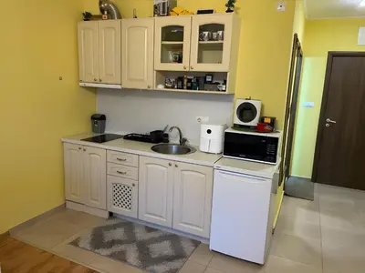 a kitchen with white cabinets and a sink and a microwave at Elegant Studio near Beach - Terrace & Parking in Nesebar