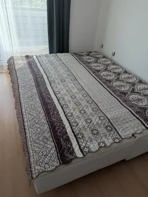 a bed with a quilt on it in a room at Sunny Day 5 in Tŭnkovo