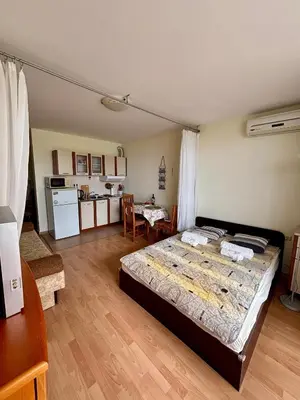 a bedroom with a large bed and a kitchen at Imperial Fort Club Studio Apartment in Sveti Vlas