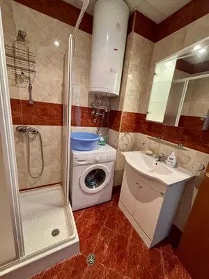a small bathroom with a washing machine and a sink at Imperial Fort Club Studio Apartment in Sveti Vlas