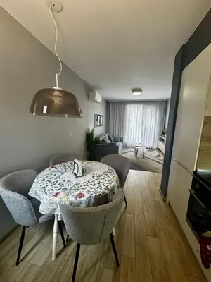a room with a table and chairs and a living room at 1BD Apartment next to the Sea Garden by Flat Mаnager in Burgas City
