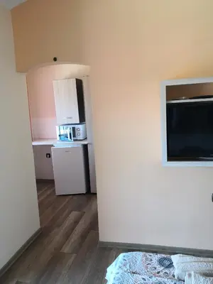 a room with a refrigerator and a kitchen with a microwave at Морската Къща in Tsarevo