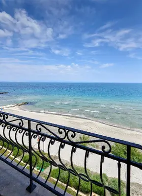 a bench on a balcony looking at the ocean at Gardenia Beach Palace Aparthotel in Pomorie