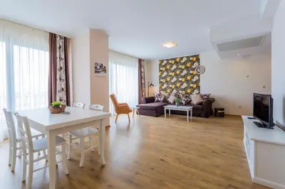 a living room with a table and a couch at Gardenia Beach Palace Aparthotel in Pomorie