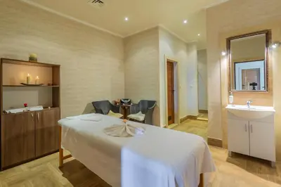 a hotel room with a bed and a sink at Gardenia Beach Palace Aparthotel in Pomorie