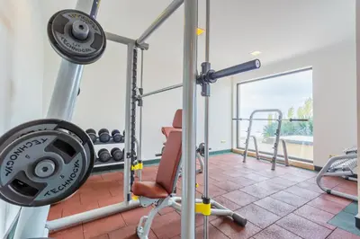 a gym with a treadmill and a chair in a room at Gardenia Beach Palace Aparthotel in Pomorie