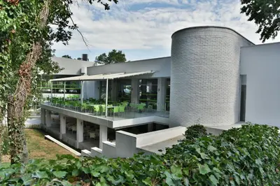 a large white house with a cylindrical building at Villas Ropotamo Maisonette in Primorsko