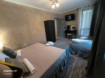 a hotel room with two beds and a television at Rali Apartments in Kiten