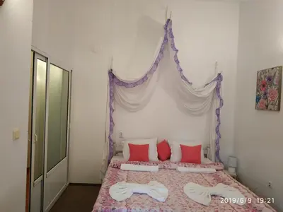 a bedroom with a bed with red and white pillows at Rali Apartments in Kiten