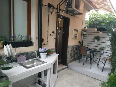 a outdoor kitchen with a sink and a table at Rali Apartments in Kiten