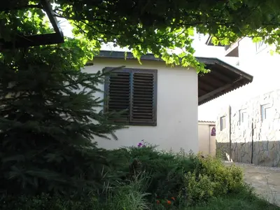 a white house with a window and a tree at Villa Magnet in Lozenets