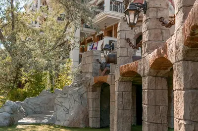 a building with a stone wall and lights on it at Harmony Suites - Dream Island in Sunny Beach