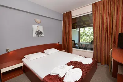a bedroom with a bed with white towels on it at Guesthouse Kirov in Ravda