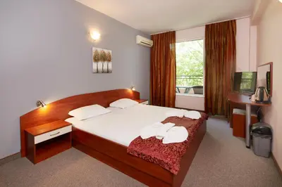a bedroom with a bed with two towels on it at Guesthouse Kirov in Ravda