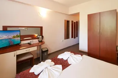 a bedroom with a bed with a desk and a television at Guesthouse Kirov in Ravda