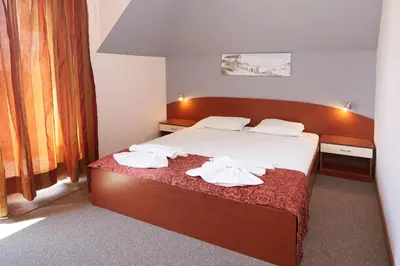 a bedroom with a bed with towels on it at Guesthouse Kirov in Ravda