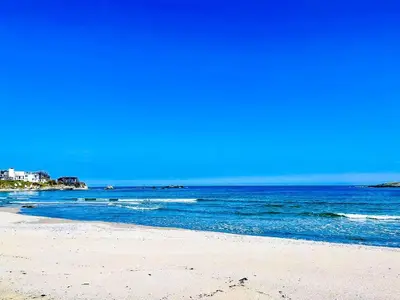 a beach with the ocean and buildings in the background at Arapya Resort in Arapya