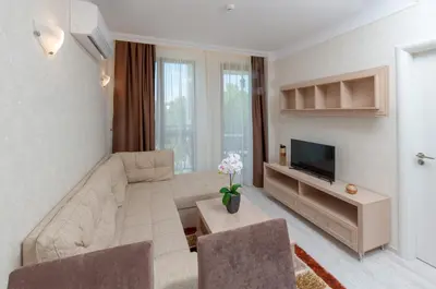 a living room with a couch and a tv at Harmony Suites Saint Vlas in Sveti Vlas