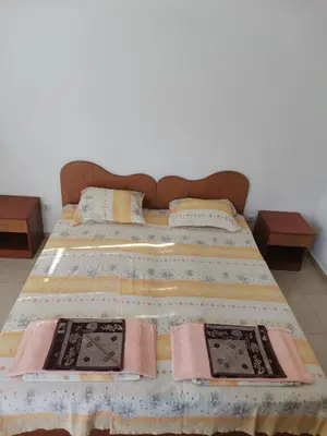 a bed with two pillows and a blanket on it at Къща за гости Кадиеви in Primorsko