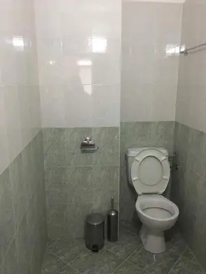 a bathroom with a toilet and a trash can at Къща за гости Кадиеви in Primorsko