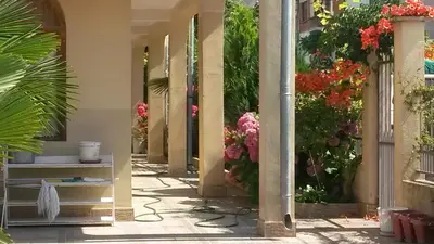 a walkway with flowers on the side of a building at Къща за гости Кадиеви in Primorsko