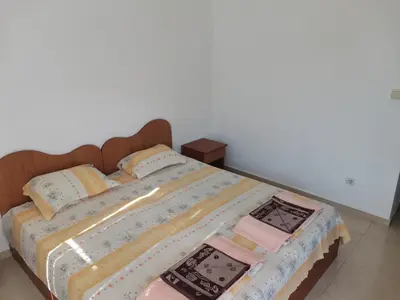 a bed with a quilt and pillows on it at Къща за гости Кадиеви in Primorsko