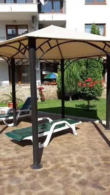 a pavilion with two lounge chairs under it at Family hotel Apolon in Nesebar
