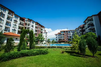 an apartment complex with a yard with a swimming pool at Family hotel Apolon in Nesebar