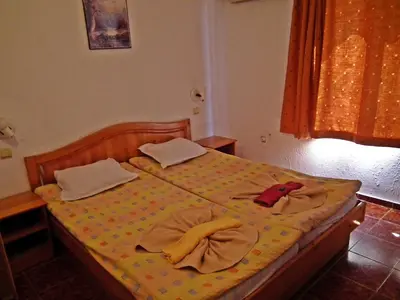 a bedroom with a bed with two towels on it at Guest House Olimpiya in Sveti Vlas