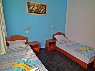 two beds in a room with blue walls at Guest House Olimpiya in Sveti Vlas