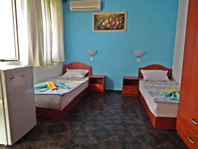 two beds in a room with blue walls at Guest House Olimpiya in Sveti Vlas