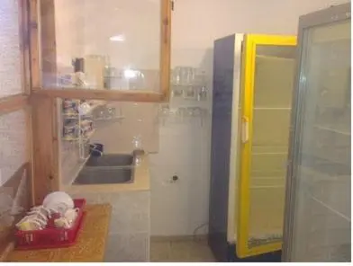 a kitchen with a sink and a yellow cabinet at Guest House Olimpiya in Sveti Vlas