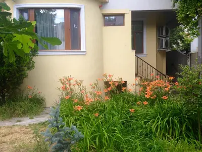 a garden in front of a house with flowers at Guest Rooms Maria Luiza in Varna City