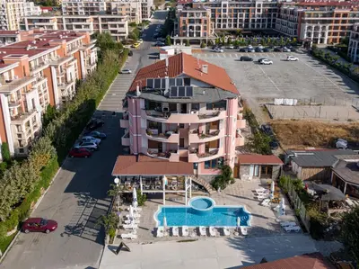 an apartment building with a swimming pool in a city at Hotel Fantasy Beach in Sveti Vlas